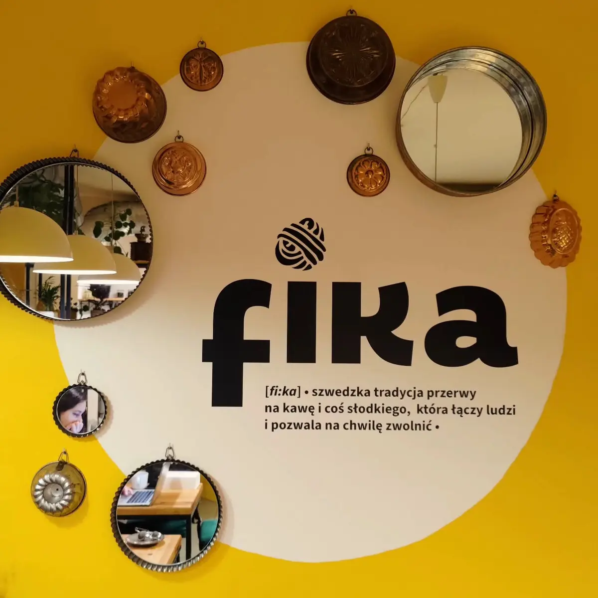 Ściana FIKI z logo, lustrami i definicją szwedzkiego rytuału